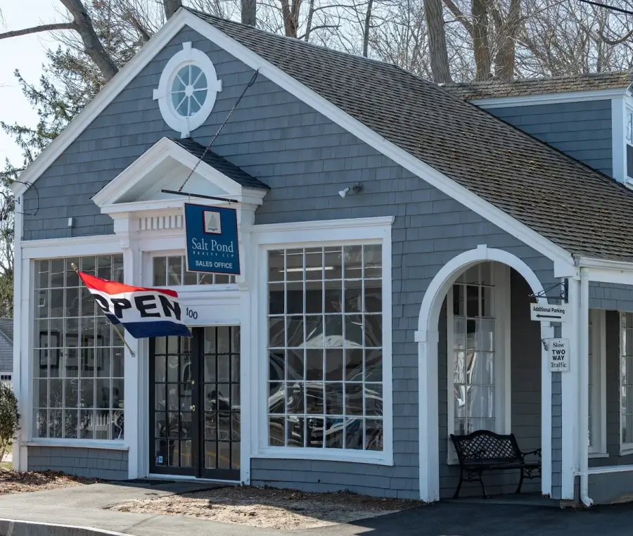 Gray building with Open sign outside.
